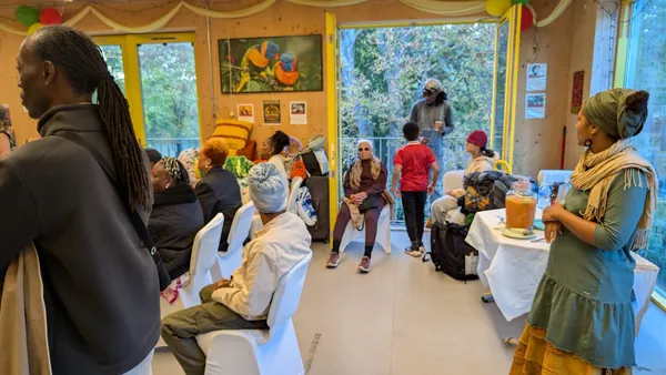 Guests seated at a community event with balloons and refreshments